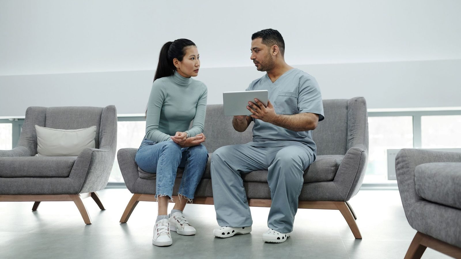 A patient and a healthcare worker talking in a bright hospital lounge (illustrative image)